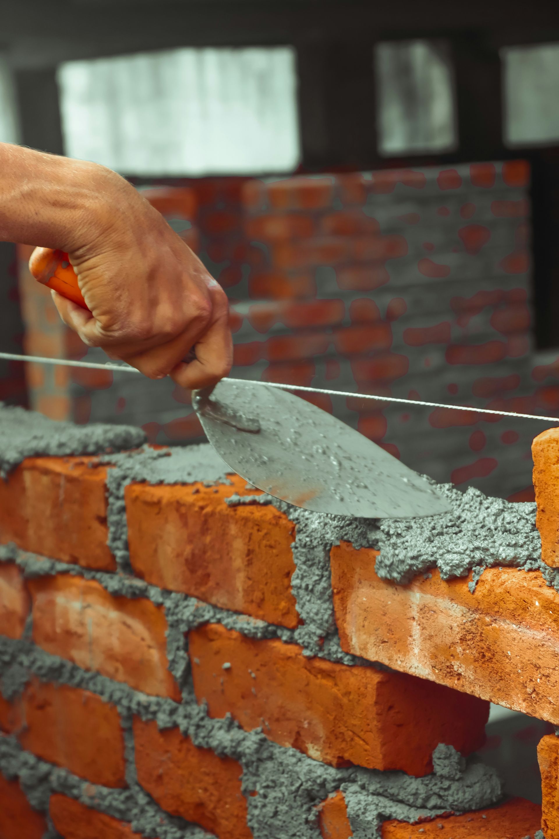 a brick wall being built with a pair of scissors